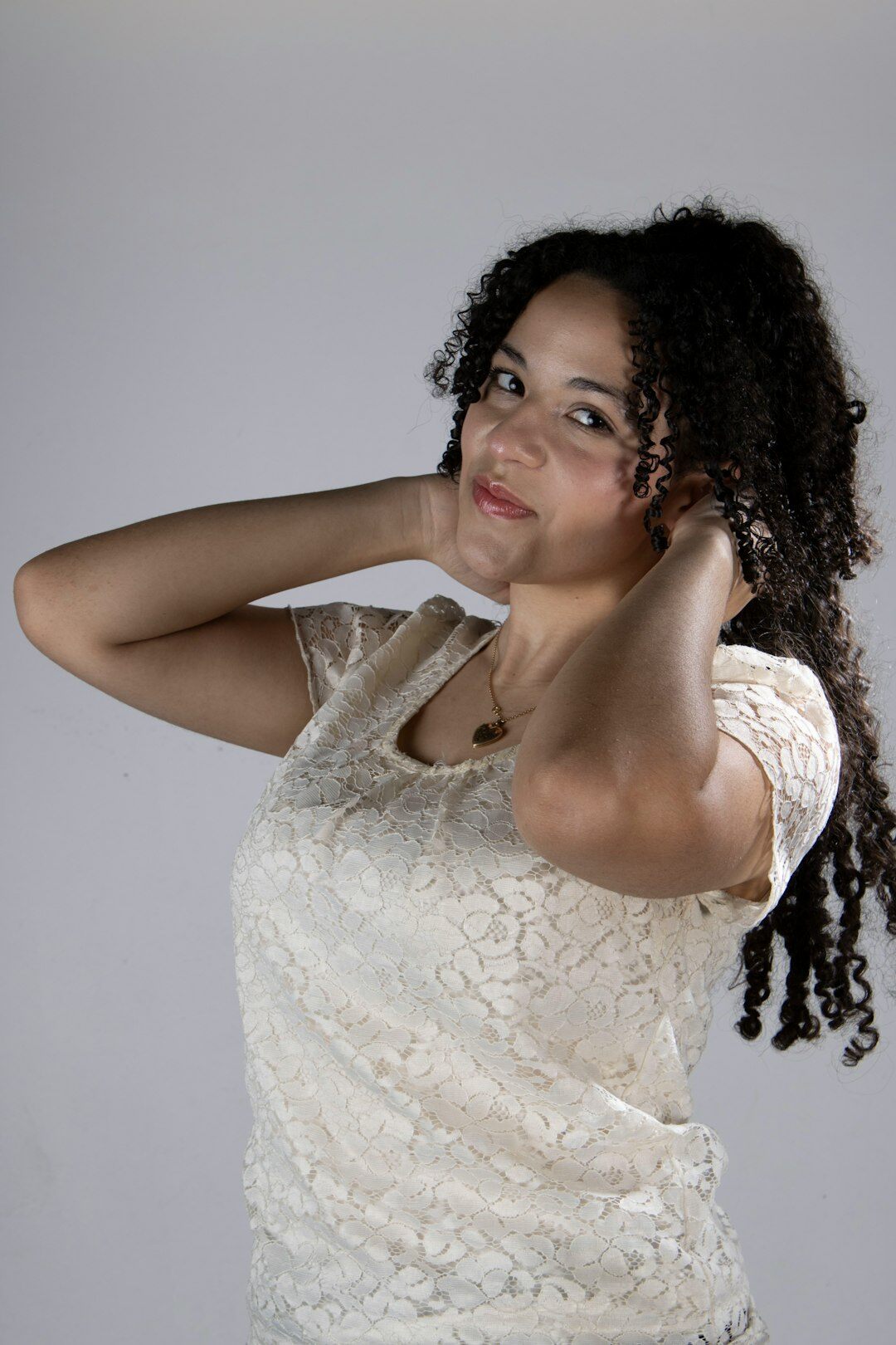 Studio portrait of a woman of North African descent in her thirties with curly hair